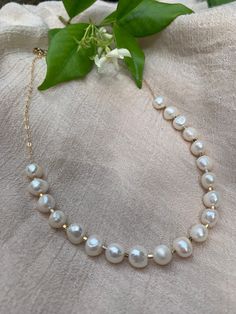 "This gorgeous necklace showcases a neckline of white Freshwater Pearls on a 14K Gold-filled chain. Beaded with small gold-filled accent beads in between each pearl. This beauty lets the iridescence of pearls take charge.  * Wear solo or layer with more of your favorite necklaces for the ultimate layered look.  * Necklace measures 16\" with 2\" extender chain. Finished with Gold-filled Lobster clasp.  * Reach out with any questions." Yellow Gold Single Strand Necklace For Wedding, White Single Strand Necklace For Wedding, White Necklace With Adjustable Chain For Wedding, White Pearl Necklace With Adjustable Chain, White Pearl Chain Necklace In 14k Gold Filled, Elegant Handmade Pearl Necklace With 14k Gold Filled, Handmade Elegant 14k Gold-filled Pearl Necklace, Handmade 14k Gold-filled Elegant Pearl Necklace, Dainty White Pearl Necklace For Anniversary