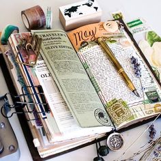 an open book sitting on top of a table next to some scissors and other items