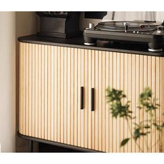 a record player sitting on top of a wooden cabinet