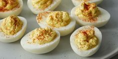 deviled eggs on a wooden cutting board with seasoning