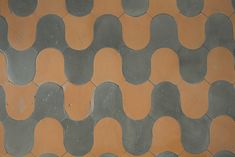 an orange and grey tile floor with wavy shapes