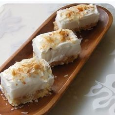 three pieces of cake sitting on top of a wooden plate