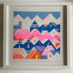 an abstract painting in white frame with pink and blue houses on it's sides