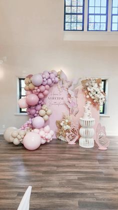 a large balloon arch in the middle of a room with pink and white balloons on it