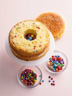 a cake sitting on top of a white plate next to two bowls filled with candy