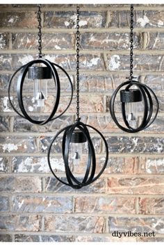 three hanging lights on a brick wall