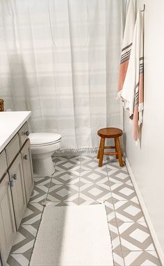 a bathroom with a stool and shower curtain