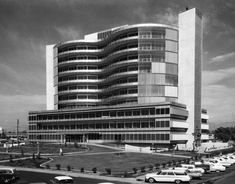 an office building with cars parked in front of it