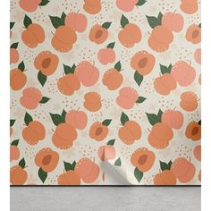 an orange and white wallpaper with peachs on the side, next to a gray floor