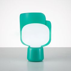 a green chair sitting on top of a white table