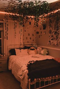 an unmade bed in a room with lights strung from the ceiling and decorations on the wall