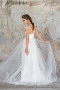 a woman in a white wedding dress with a long veil on her head and shoulders