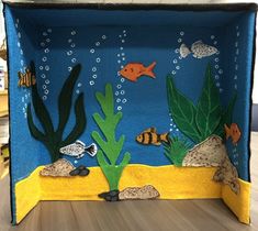 an underwater scene made out of felt with seaweed and fish on the bottom part