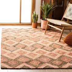 an area rug in the middle of a room with a chair and potted plant