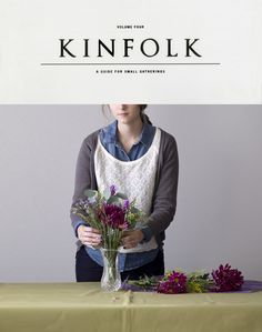 a woman arranging flowers on a table with the words kinfolk above her head