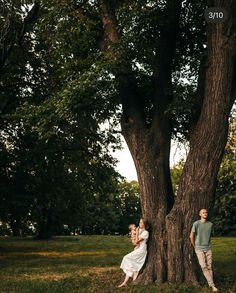 two people standing next to a large tree