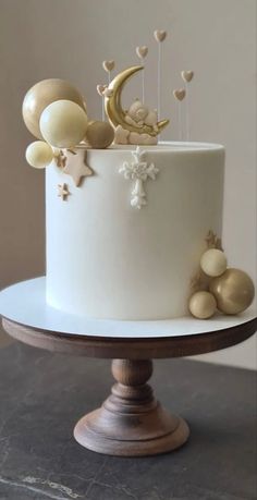 there is a white cake with gold decorations on the top and moon in the middle