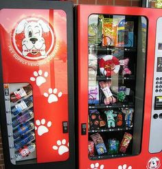 a vending machine with dogs paw prints on the front and side doors, in front of a brick wall