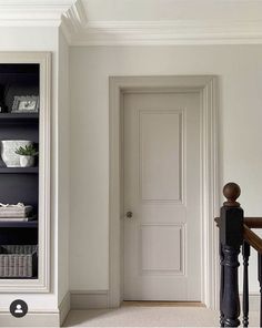 a white door and some black shelves in a room