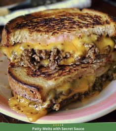 a grilled cheeseburger is on a pink and white plate with the words patty melts with secret sauce