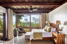 a bedroom with a large bed and wooden ceiling