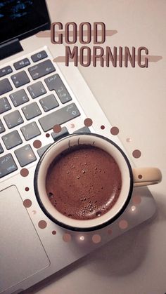 a cup of hot chocolate sitting on top of a laptop computer with the words good morning above it