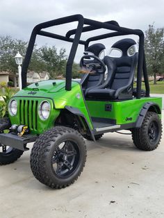 a green and black golf cart parked in a driveway