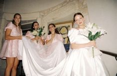 four bridesmaids pose with their dresses flowing in the wind