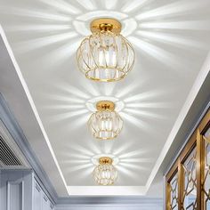 three lights that are on the ceiling in a room with white walls and flooring