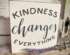 a sign that says kindness changes everything with lavenders on the table next to it