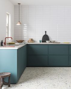 a kitchen with blue cabinets and white tile flooring is pictured in this image, the counter tops are painted teal