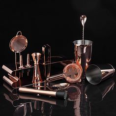 a black table topped with lots of different types of utensils and cups on top of it