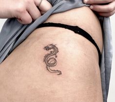 a woman's thigh with a tattoo on the side that has a snake on it