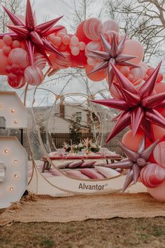 the balloon arch is decorated with stars and pink balloons for an outdoor party or celebration