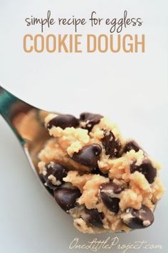 a spoon filled with cookie dough on top of a white table next to a sign that says simple recipe for eggless cookie dough