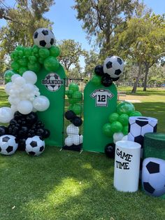 soccer themed birthday party with balloons and decorations on the grass in front of a gate