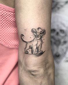 a small lion tattoo on the arm