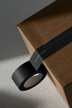 an open box with a black ribbon on it and a light coming from the top