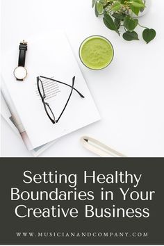 a white table topped with a green smoothie next to a cup of coffee and a notebook