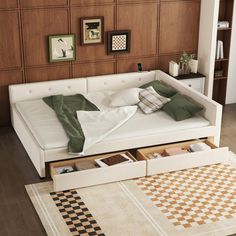 a white bed with drawers underneath it in a room that has wood paneling on the walls