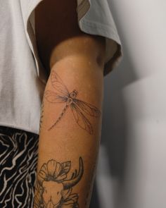 a woman with a dragonfly tattoo on her arm