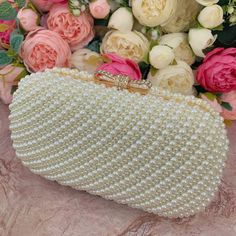 This luxurious encrusted pearl bridal clutch never fails to turn heads with its understated elegance and classic design. Adorned with varying sized ivory pearls and enhanced with a large creamy pearl clasp, this bridal clutch is the very picture of refinement. This elegant bridal clutch features rose gold trim, attachable chain and large enough for your phone. Complete your list of must-have wedding accessories with the ultimate bridal accessory to finish off your look and storing your wedding d White Pearl Evening Bag For Party, Pearl Clutch For Party, Pearl Embroidered Party Clutch, Elegant Pearl White Party Clutch, Pearl White Clutch For Parties, Pearl Clutch With Pearl Embroidery For Evening, Pearl Embellished Evening Bag For Party, Formal Gold Clutch With Pearl Material, Gold Pearl Clutch With Pearl Embroidery