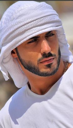 a man wearing a white hat and looking at the camera with a serious look on his face