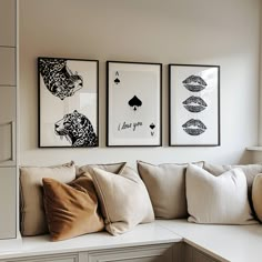 three framed pictures hang on the wall above a white couch with pillows and throw pillows