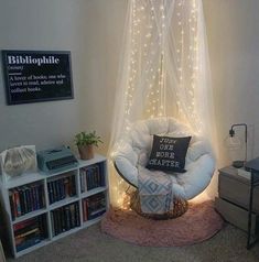 a room with a chair, bookshelf and some lights on the wall above it