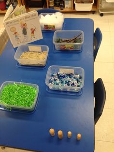 several plastic containers filled with different types of food on a blue table in a classroom