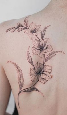 the back of a woman's shoulder with flowers and leaves on her left side