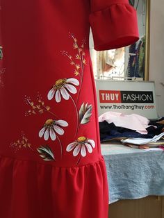 a woman's red dress with daisies on it