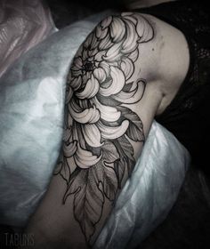 a woman's arm with flowers and leaves on it