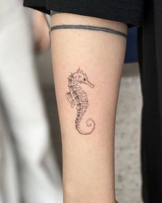 a small sea horse tattoo on the right arm